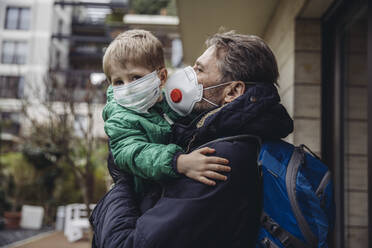 Vater mit Sohn, beide mit Schutzmaske, im Freien - MFF05084