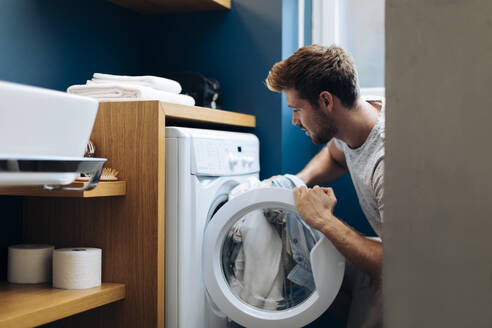 Young man doing the laundry at home - SODF00707