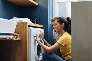Junges Paar wäscht zu Hause die Wäsche - SODF00728