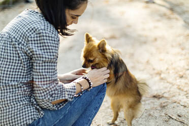 Young woman playing with dog outdoors - SODF00731