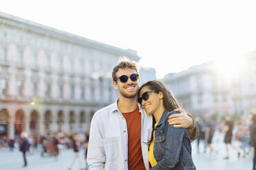 Happy young couple on a square in the city at sunset, Milan, Italy - SODF00735