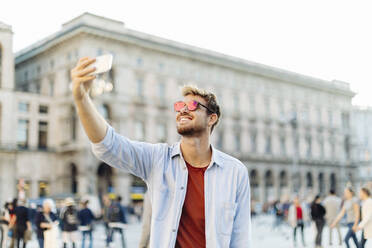 Smiling young man taking a selfie in the city, Milan, Italy - SODF00736