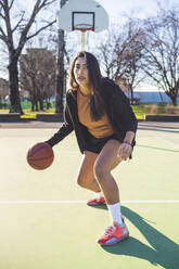 Portrait of female basketball player in action on court - MEUF00068
