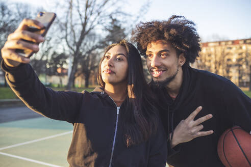 Junges sportliches Paar macht ein Selfie bei Sonnenuntergang - MEUF00095