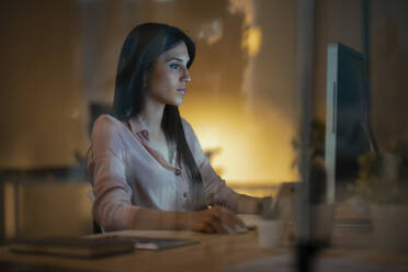 Junge Frau arbeitet am Schreibtisch im Büro - JSRF00915