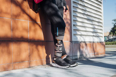 Close-up of legs of sporty woman with leg prosthesis in the city - MEUF00104