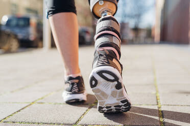 Close-up of legs of sporty woman with leg prosthesis in the city - MEUF00105