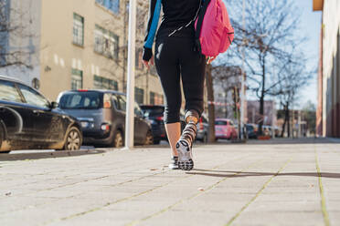 Sportliche junge Frau mit Beinprothese beim Spaziergang in der Stadt - MEUF00106