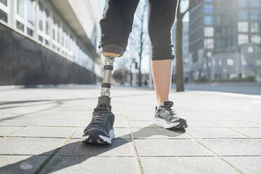 Close-up of legs of sporty woman with leg prosthesis in the city - MEUF00122