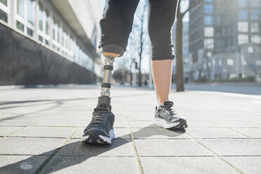Nahaufnahme der Beine einer sportlichen Frau mit Beinprothese in der Stadt - MEUF00122