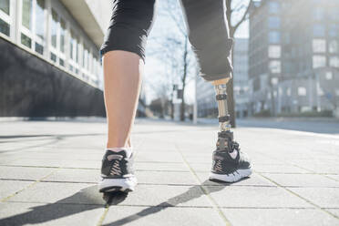 Close-up of legs of sporty woman with leg prosthesis in the city - MEUF00123