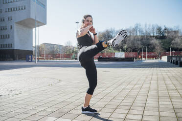 Portrait of happy sporty young woman with leg prosthesis in the city - MEUF00127