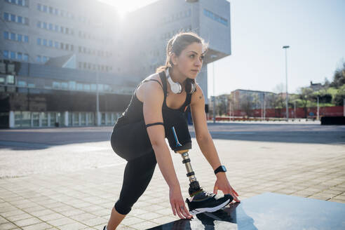 Porträt einer sportlichen jungen Frau mit Beinprothese in der Stadt - MEUF00128