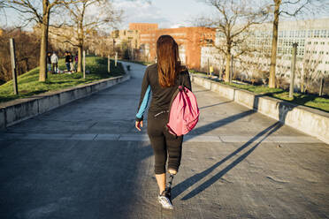Sportliche junge Frau mit Beinprothese beim Spaziergang in der Stadt - MEUF00166