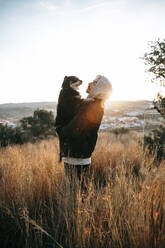 Junger Mann mit seinem Hund bei Sonnenaufgang, Montroy, Spanien - AMAF00002