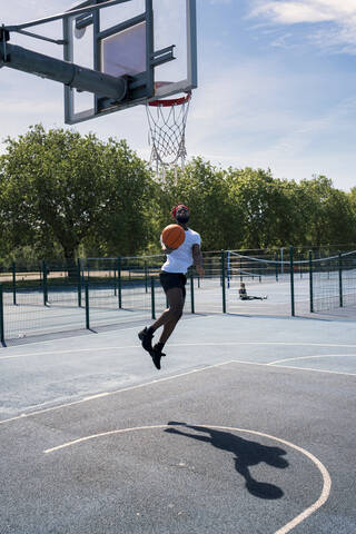 Man playing basketball, dunking stock photo