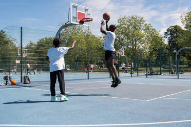 Vater und Sohn spielen Basketball auf dem Basketballplatz - JPIF00500