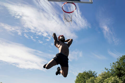 Mann, der Basketball spielt und eintaucht, lizenzfreies Stockfoto
