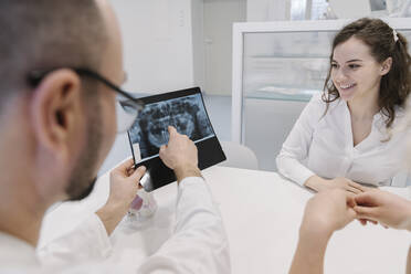 Zahnarzt spricht mit dem Patienten über die Röntgenergebnisse - AHSF02039