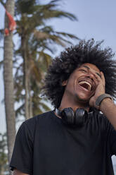 Portrait of laughing young man with headphones - VEGF01780