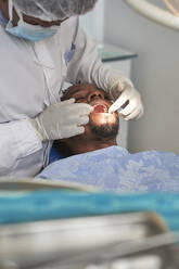 Female dentist examining teeth of a man - VEGF01784