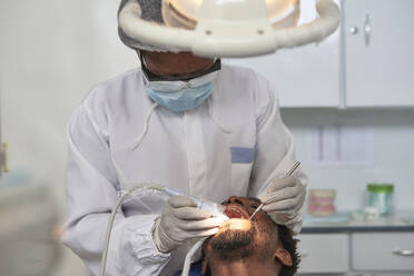 Zahnärztin bei der Zahnreinigung eines Mannes - VEGF01786