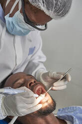 Female dentist cleaning teeth of a man - VEGF01787