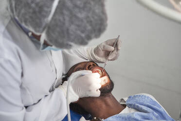 Zahnärztin bei der Zahnreinigung eines Mannes - VEGF01788