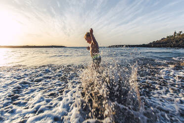 Junge spielt im Wasser an der Strandpromenade, Adeje, Teneriffa, Kanarische Inseln, Spanien - IHF00265