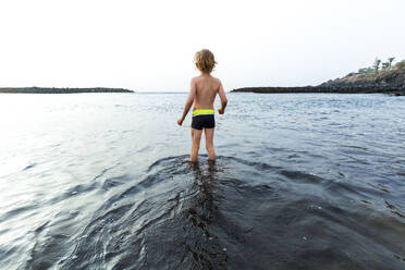 Rückansicht eines Jungen am Strand, Adeje, Teneriffa, Kanarische Inseln, Spanien - IHF00270