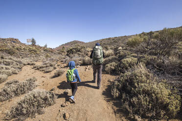 A father and his son trekking in the Arenas Negras area, Teide National Park, Tenerife, Spain - IHF00287