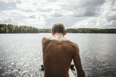 Rückansicht des hemdlosen Jungen, der am See steht - EYF01052