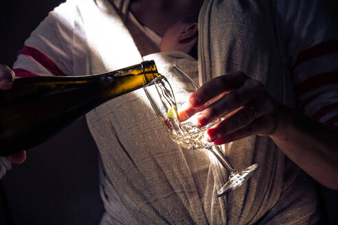 Nahaufnahme einer Frau, die Wein aus einer Flasche gießt - EYF01053