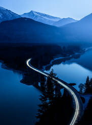 High Angle View of Light Trails auf der Brücke über den Fluss in der Abenddämmerung - EYF01063