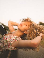 Young Woman Leaning From Car Window Against Clear Sky - EYF01137