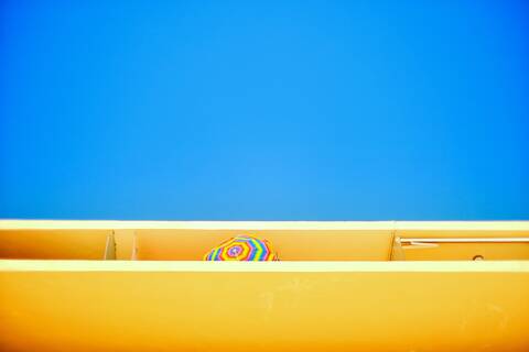 Low Angle View of Balkon mit Sonnenschirm gegen klaren blauen Himmel, lizenzfreies Stockfoto