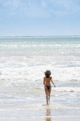 Eine junge Frau läuft in den tropischen Atlantik, Insel Morro de Sao Paulo, Bahia, Brasilien, Südamerika - RHPLF14197