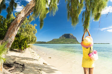 Frau amüsiert sich unter einem tropischen Baum am Sandstrand, Ile aux Benitiers, La Gaulette, Le Morne Brabant, Mauritius, Indischer Ozean, Afrika - RHPLF14201