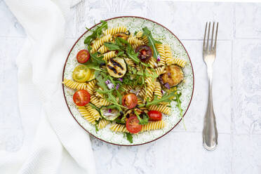 Teller mit vegetarischem Nudelsalat mit gegrillten Zucchini, Tomaten, Rucola, roten Zwiebeln und Balsamico-Essig - LVF08670