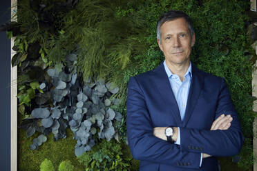 Portrait of confident businessman in green office - RBF07194