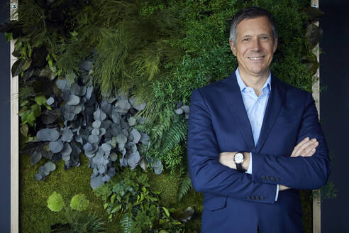 Portrait of smiling businessman in green office - RBF07195