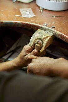 Man repairing a ring with a missing diamond - VEGF01789