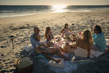 Familie und Freunde genießen ein Picknick am Strand während des Sonnenuntergangs, Riviera Nayarit, Mexiko - ABAF02291