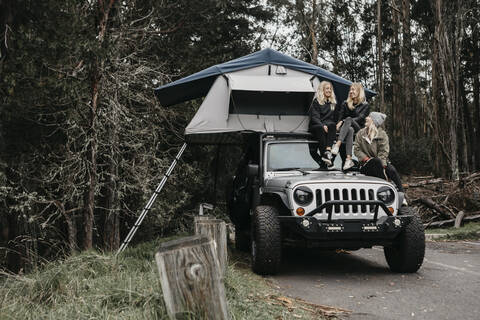 Glückliche Freunde unterhalten sich beim Zelten im Jeep im Haleakala-Nationalpark, Maui, Hawaii, USA, lizenzfreies Stockfoto