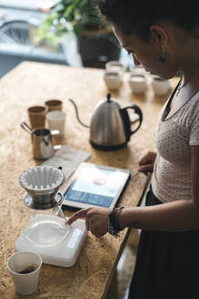 Frau arbeitet in einer Kaffeerösterei und bereitet frischen Filterkaffee zu - JPIF00538
