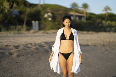 Schöne junge Frau im Bikini genießt beim Spaziergang am Strand, Marbella, Andalusien, Spanien - JSMF01487