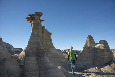 Hiking around hoodoo sandstone formations in Bisti/De-Na-Zin Wilderness, New Mexico, United States of America, North America - RHPLF14520