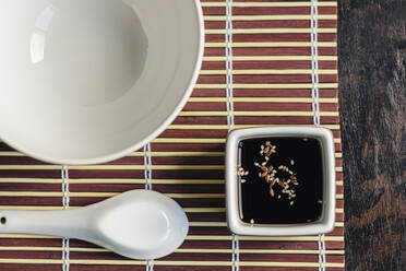 Vessel with soy sauce and sesame on an oriental table setting - CAVF77273