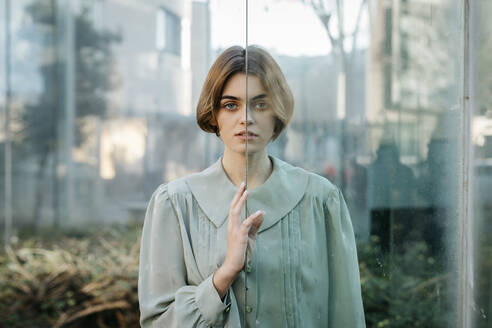 Portrait of woman with her face resting on a glass pane - TCEF00257