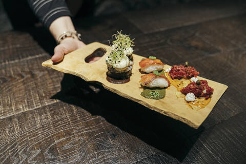 Spnaische Gourmetgerichte von Hand auf einem Brett serviert, lizenzfreies Stockfoto